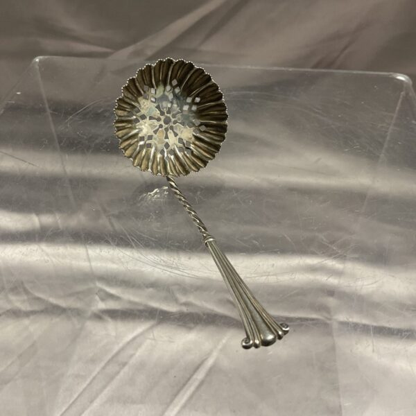 Antique silver sugar sifter with pierced floral bowl.