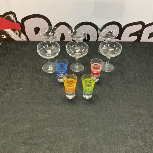 Set of four colourful crystal gin glasses on a patterned surface.