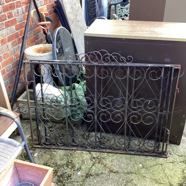 Antique wrought iron gates with scrolling details for garden use.