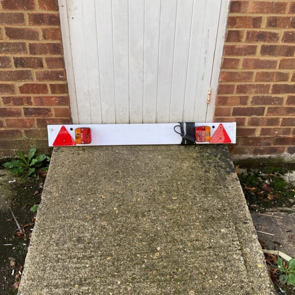 Red lens tailboard light for trailer or commercial vehicle.