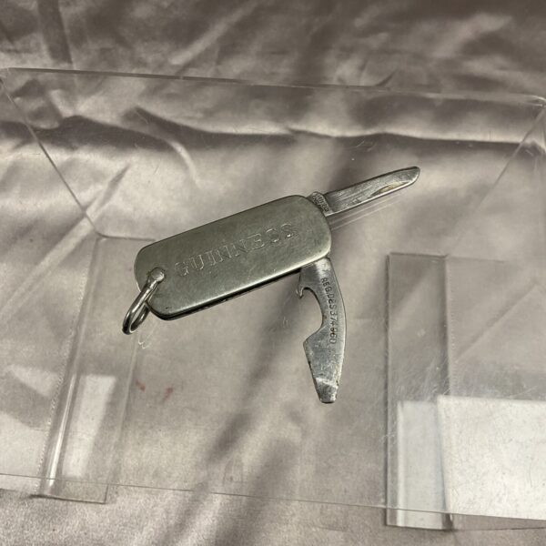 Vintage Guinness bottle opener penknife with embossed logo.