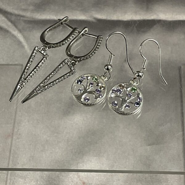 Close-up of silver earrings with amethyst-coloured stones.