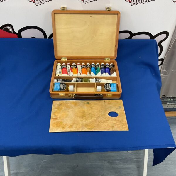 Vintage wooden paint box with assorted paints inside.
