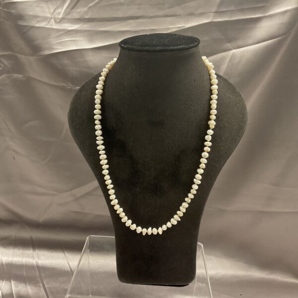 Vintage freshwater pearl necklace displayed on a mannequin.