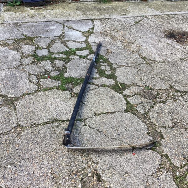 Antique garden scythe with curved blade and wooden handle.