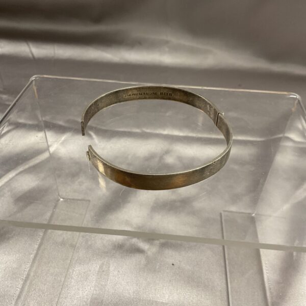 Hallmarked sterling silver hinged bracelet, vintage jewellery detail.