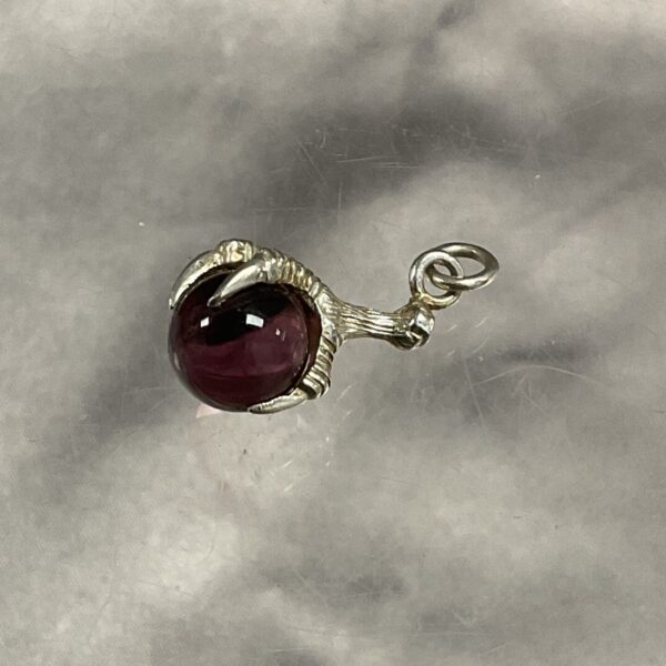 Vintage bird claw pendant with a red stone.