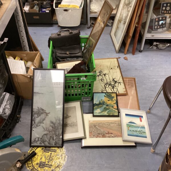 Mixed lot of vintage oriental prints and leather bags on display.