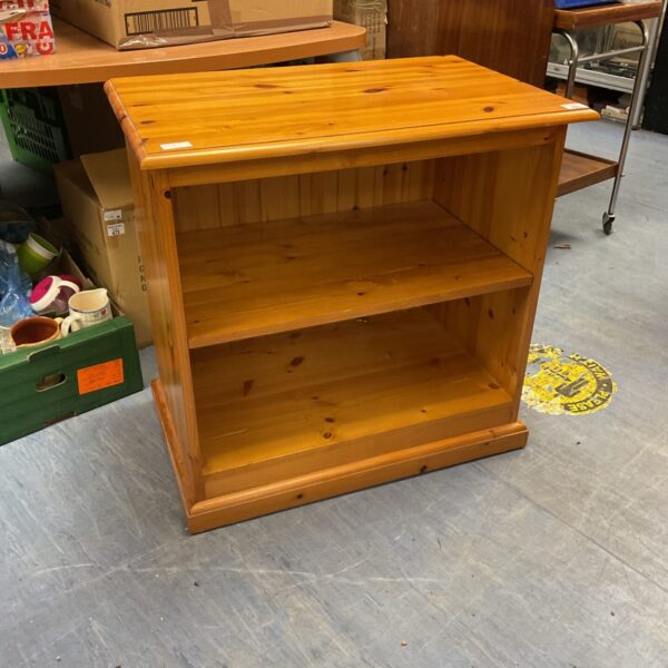 Small pine bookshelf with two shelves, rustic wooden design.