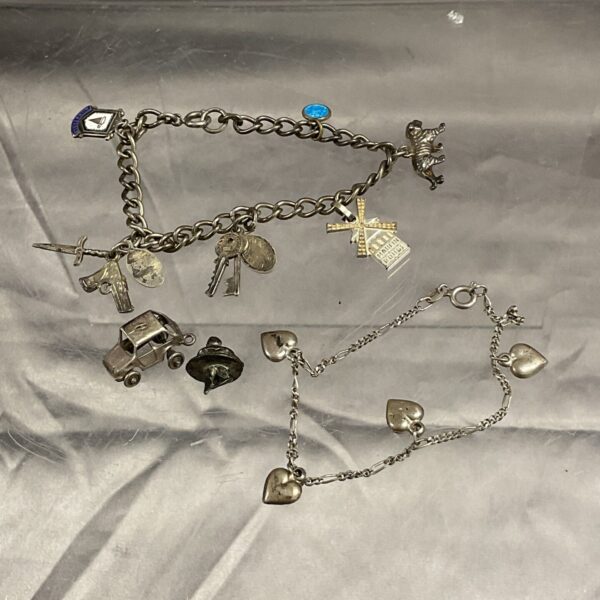 Vintage silver charm bracelets with detailed miniature charms.