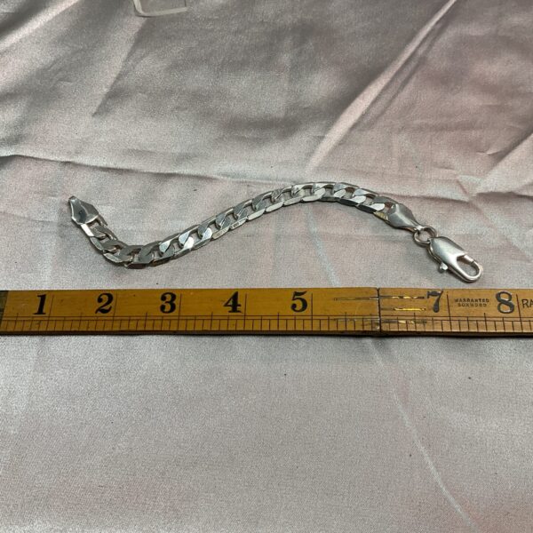 Close-up of a 925 silver curb chain bracelet with a lobster clasp.