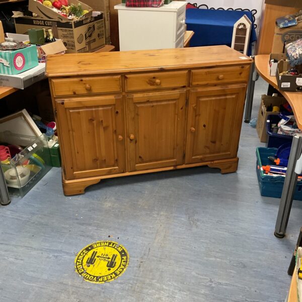 Vintage pine sideboard on wheels with cupboards and drawers.
