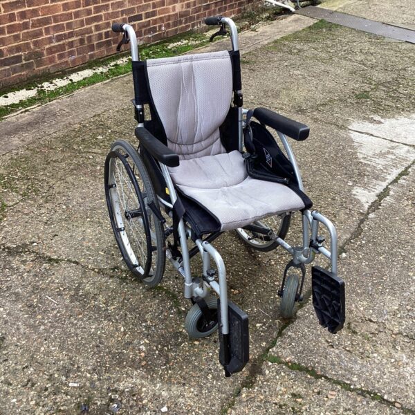 Grey folding wheelchair, a practical mobility aid for users.