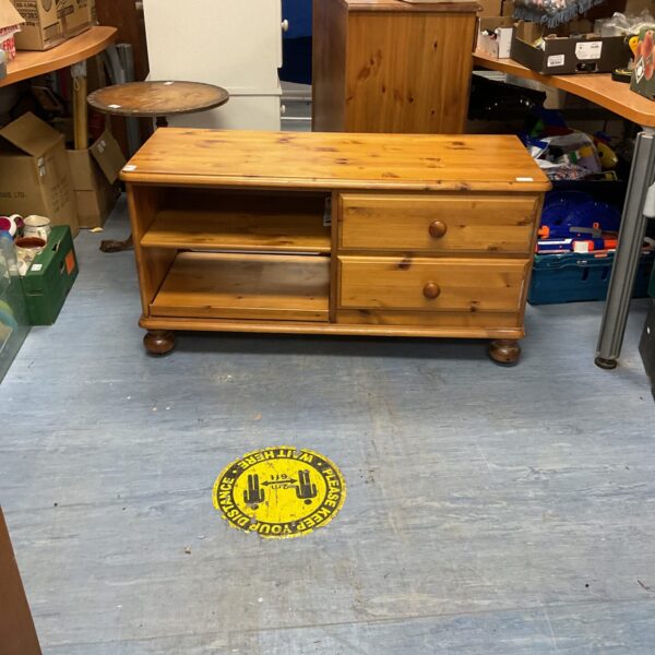 Front view of a rustic pine media cabinet with two drawers.