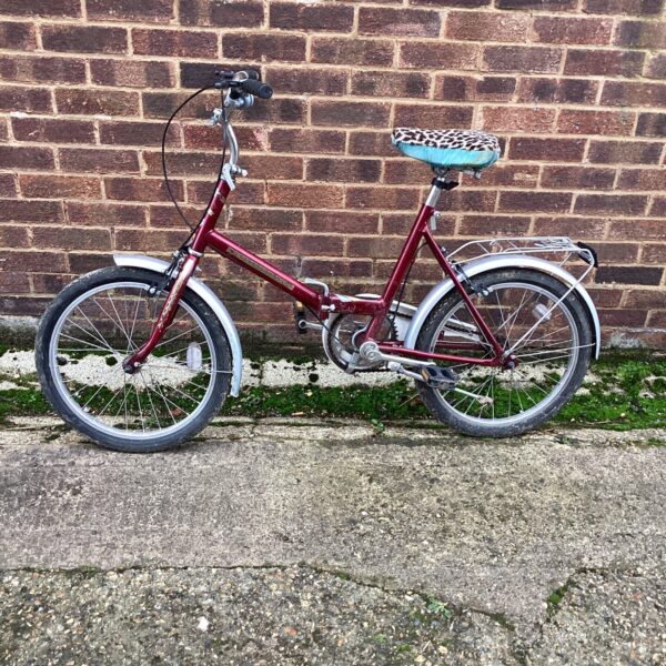 Red vintage folding bicycle, a compact cycle for restoration.