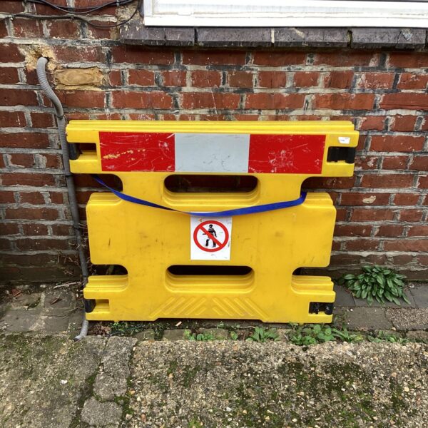 Yellow plastic hazard barrier for safety and demarcation.
