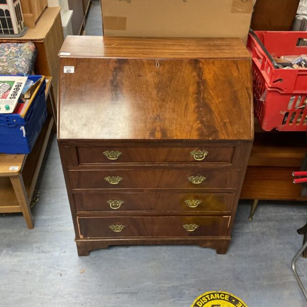Dark wood vintage writing desk with three drawers.