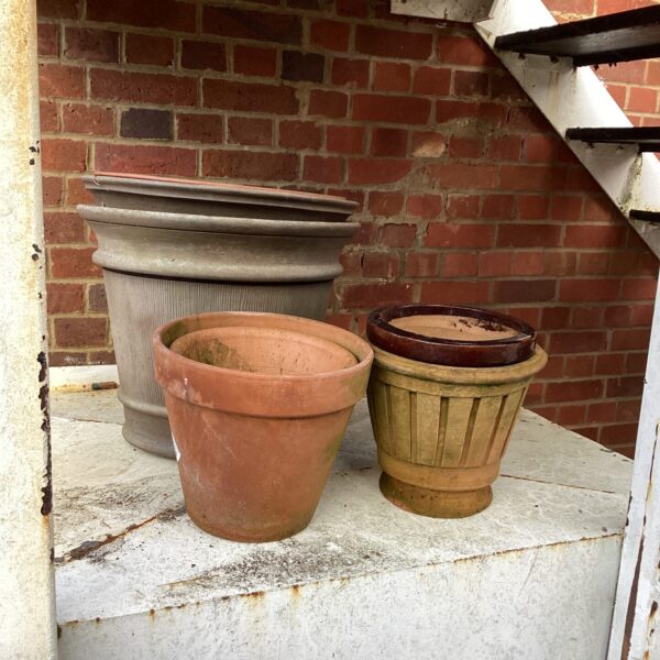 Selection of weathered terracotta garden planters for outdoor use.