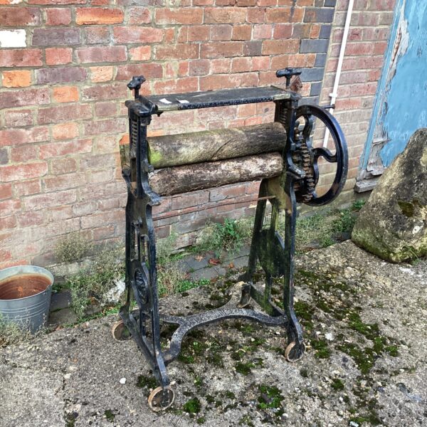 Antique washing mangle with wooden roller and cast iron frame.