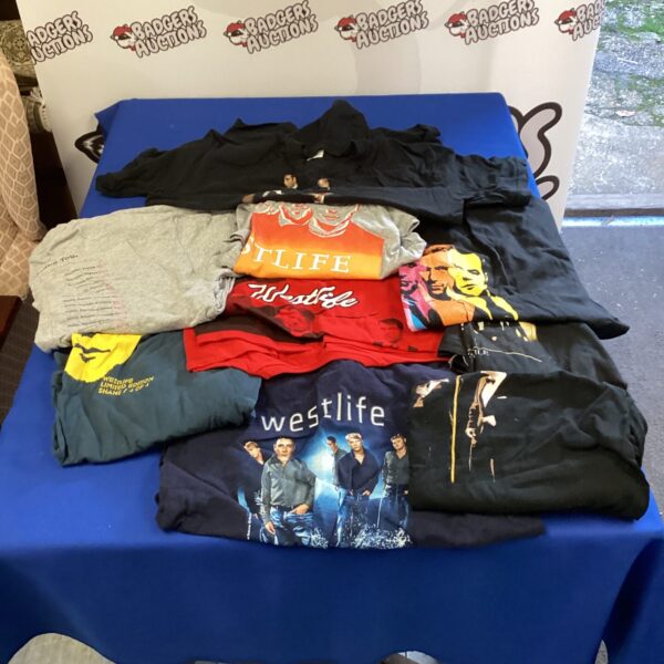 A lot of nine Westlife T-shirts, showcasing band merchandise.