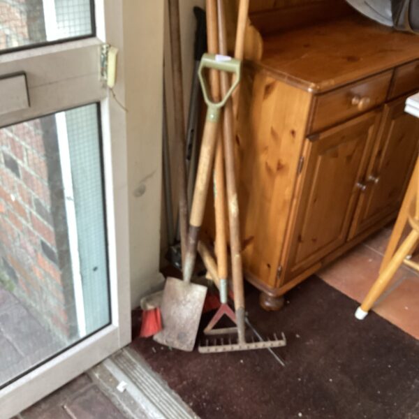 Selection of vintage garden tools including hoes and rakes.