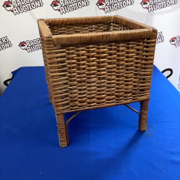 Vintage wicker pot stand for plants, rustic garden decor.