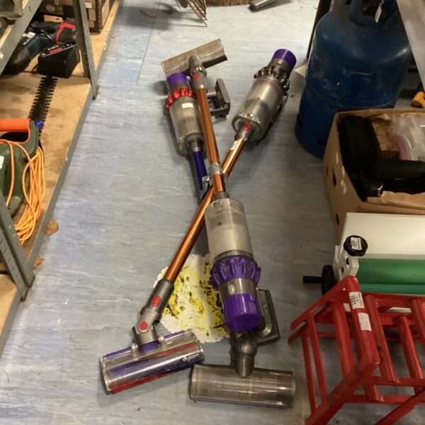 Lot of three Dyson cordless vacuum cleaners in used condition.