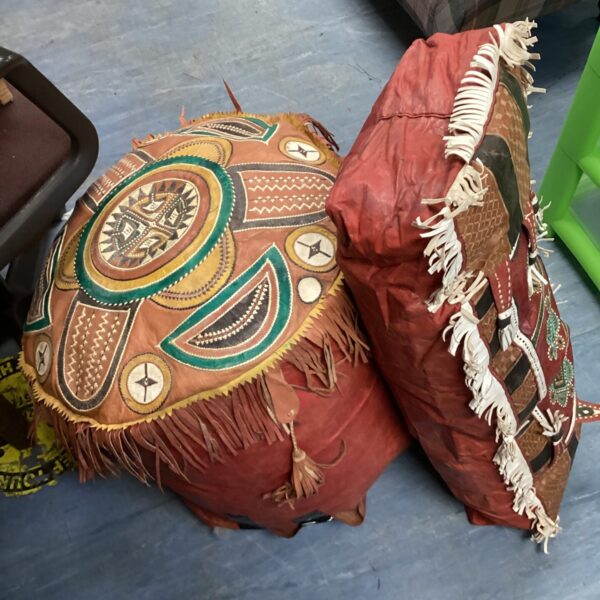 Intricate leather Moroccan footstool with fringe detail.