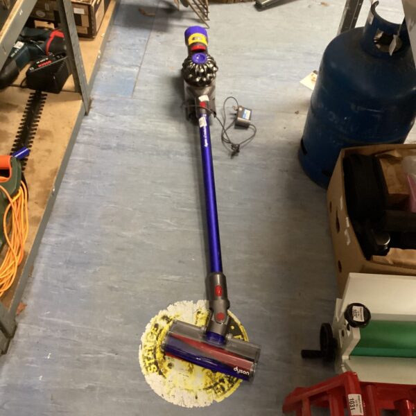 Used Dyson V8 cordless vacuum cleaner in a home setting.