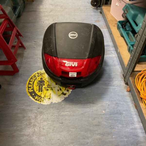 Black Givi motorcycle top box, side view.