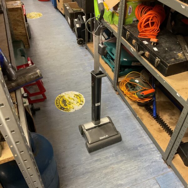 Gtech AirRam cordless vacuum cleaner in a workshop setting.