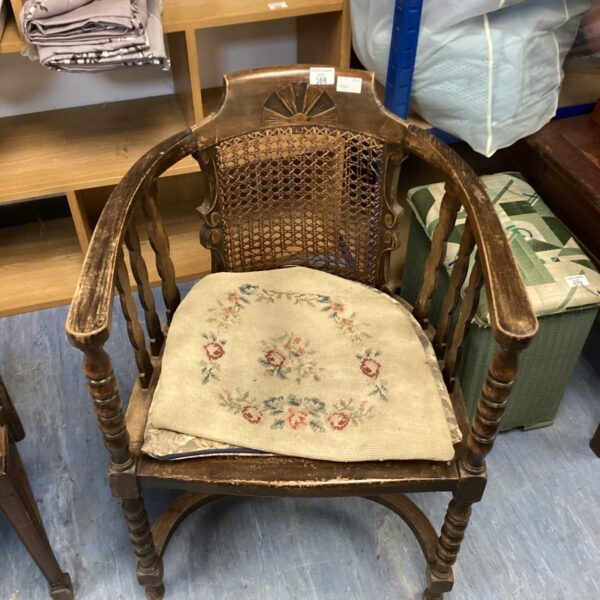 Antique rising sun carver chair with worn upholstery.
