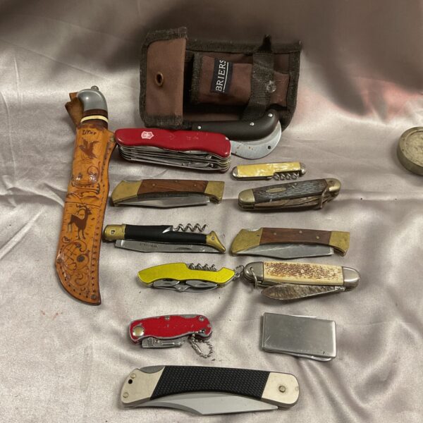 Vintage knife collection including a Swiss Army knife and sheath knife.
