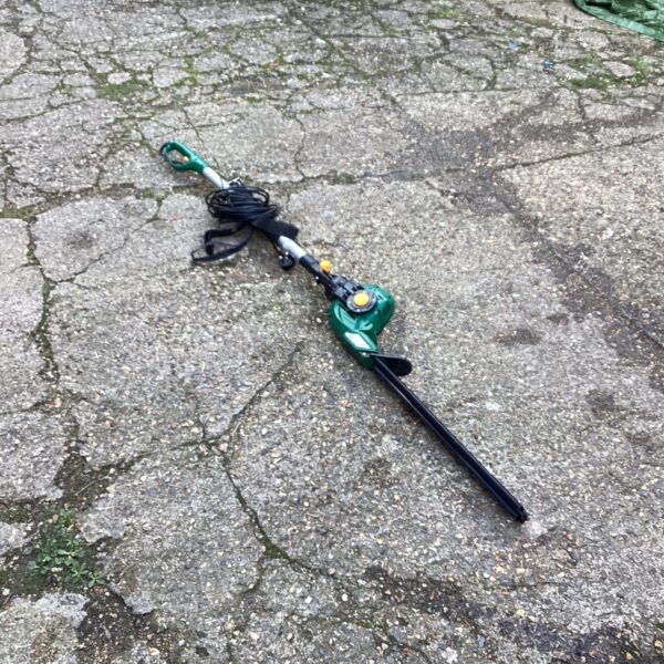 Electric pole hedge cutter for garden maintenance and trimming.