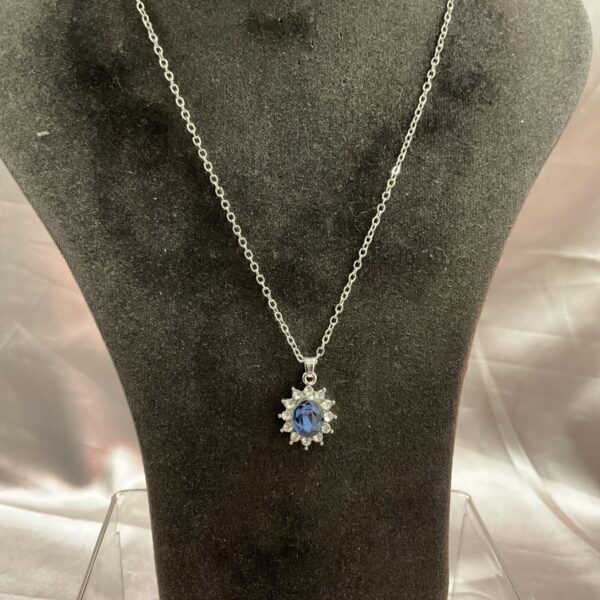 Close-up of amethyst pendant necklace with white stone halo.