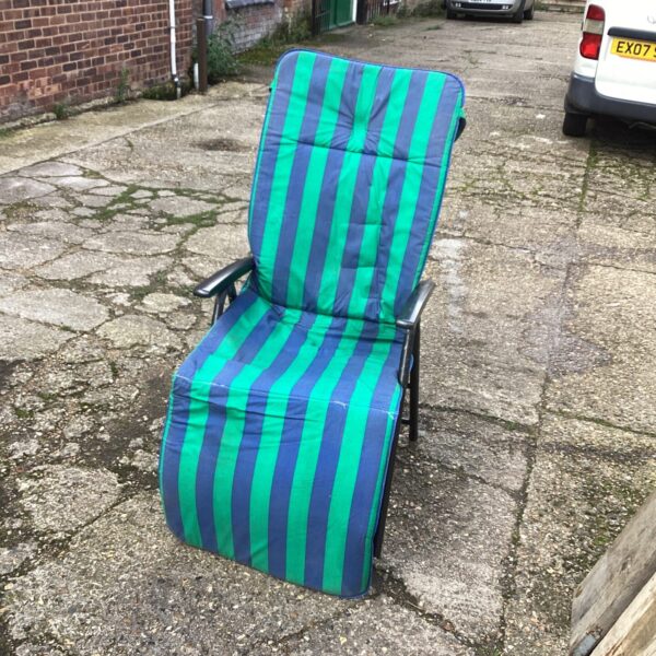 Striped reclining garden chair in a residential setting.