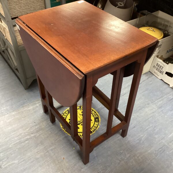 Vintage mahogany gate leg table with drop leaf design.