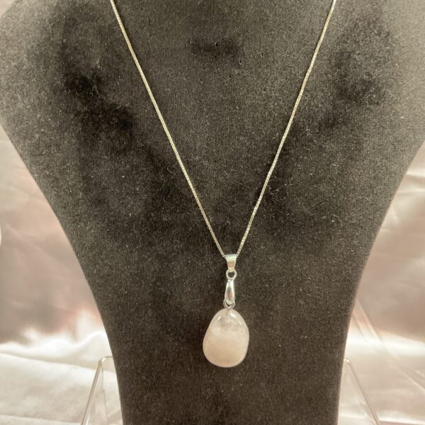 Delicate silver necklace with a pale pink stone pendant.