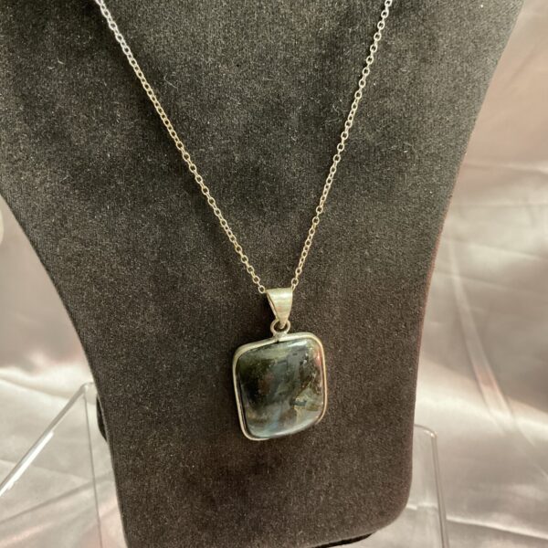 Close-up of a stunning boulder opal pendant on a silver chain.