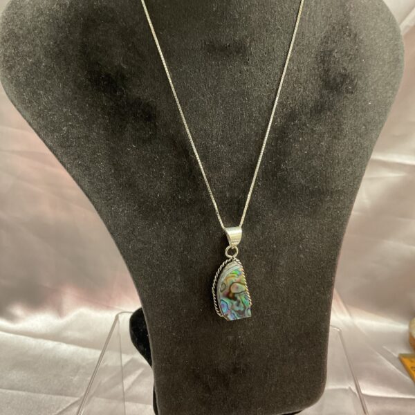 Iridescent abalone stone pendant on a silver necklace.