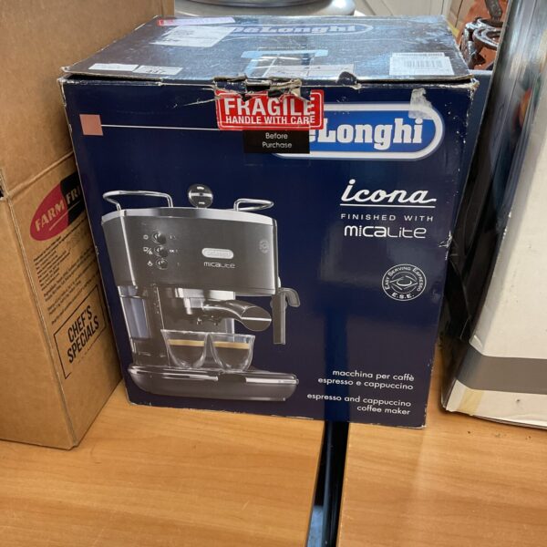 Front view of a DeLonghi espresso machine in its original packaging.