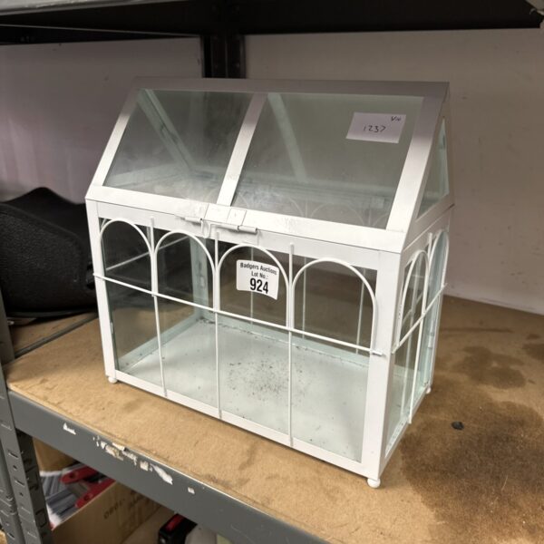 White miniature greenhouse for indoor herb gardening and plant display.