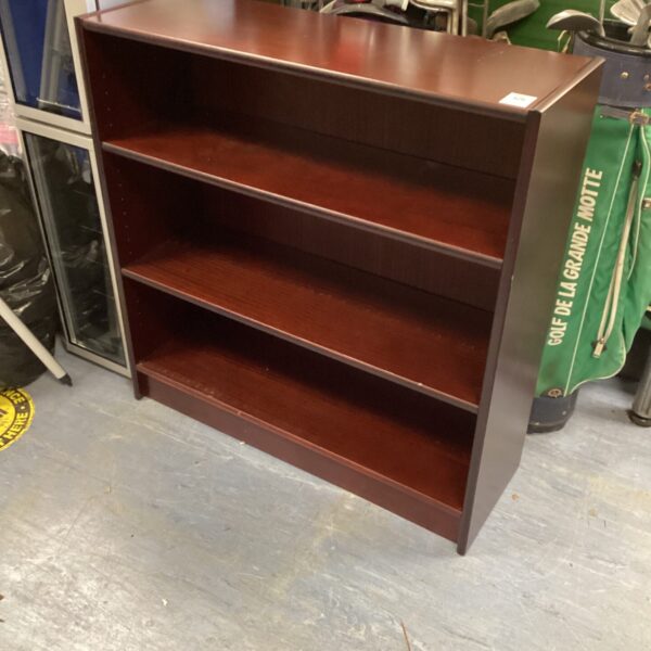 Vintage mahogany bookcase with three shelves for storage.