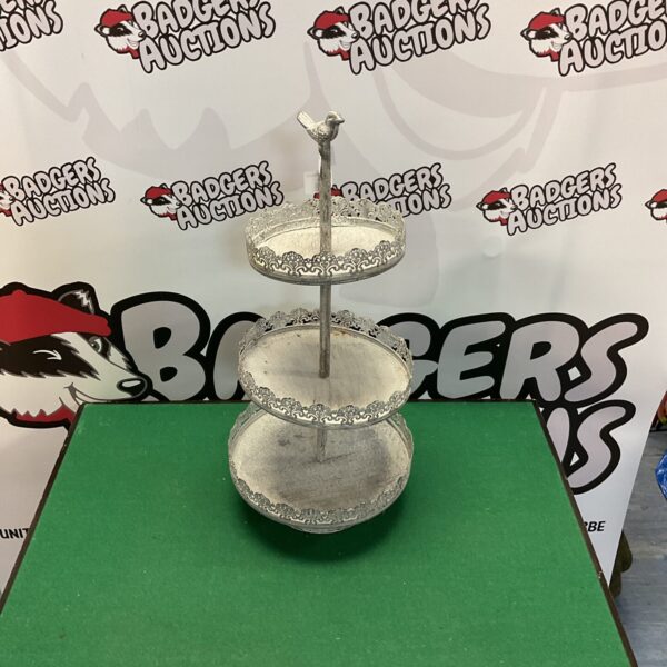 Vintage three-tier metal cake stand for displaying desserts.