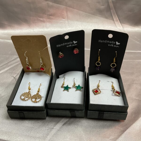Six pairs of colourful fashion earrings displayed on a card.