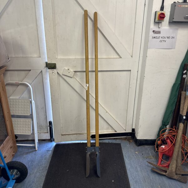 Pair of long-handled fence post hole digging spoons for garden work.