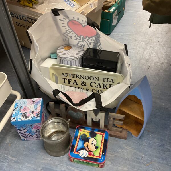 Mixed tin and household lot with vintage tins and a wooden sign.