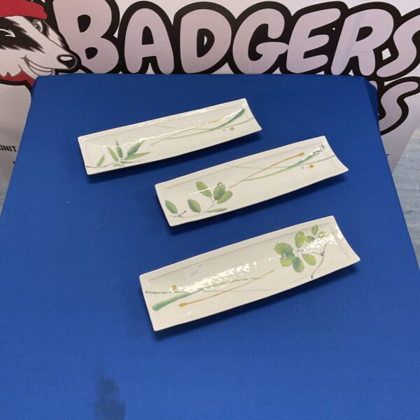 Set of three Japanese sushi dishes with floral design.