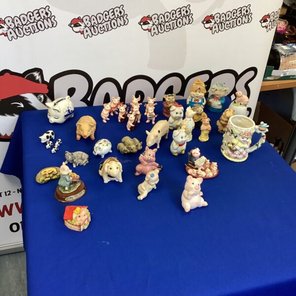 Large collection of porcelain pig ornaments displayed on a surface.