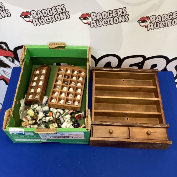 Vintage thimble collection displayed in a wooden case.